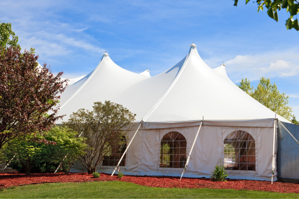 A white event tent set up outdoors on a clear day.